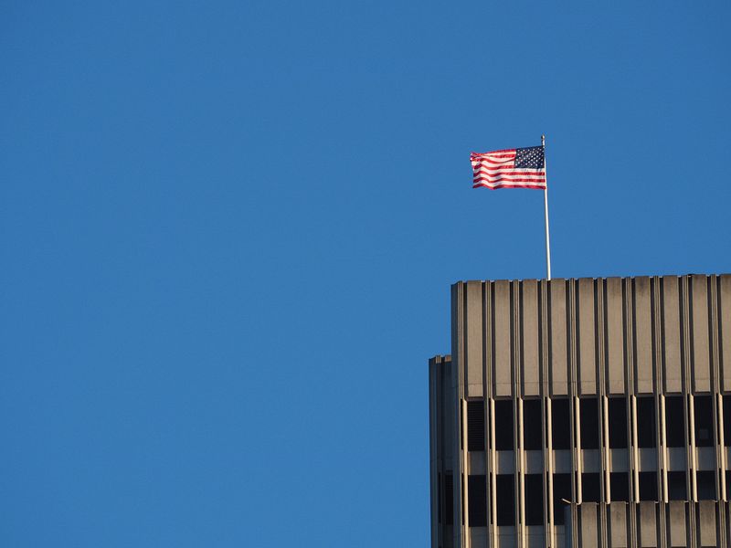 American flag at the top of a tall building